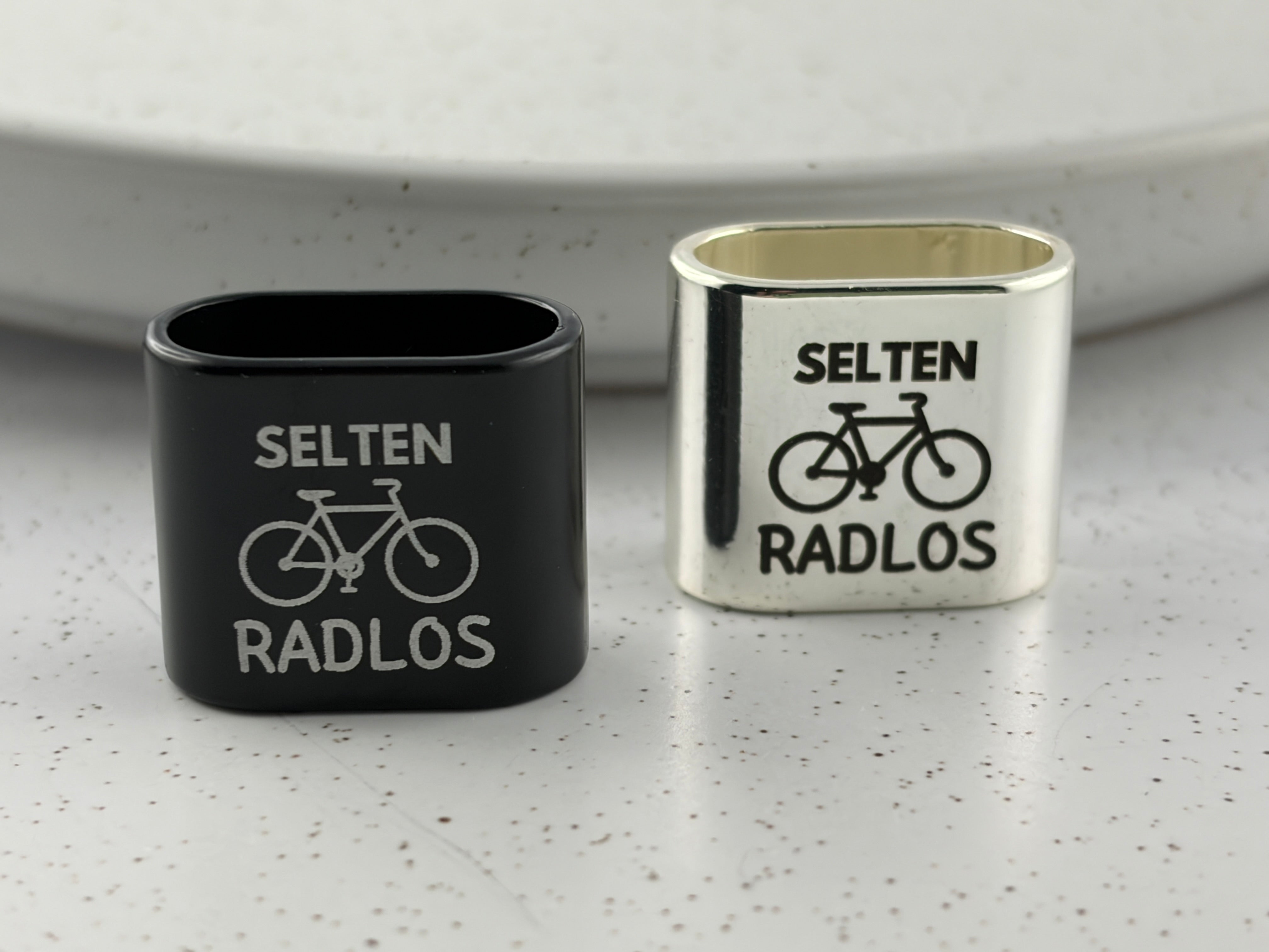 Detailaufnahme der Gravur "Selten Radlos" mit Fahrradsymbol auf dem Zwischenstück.