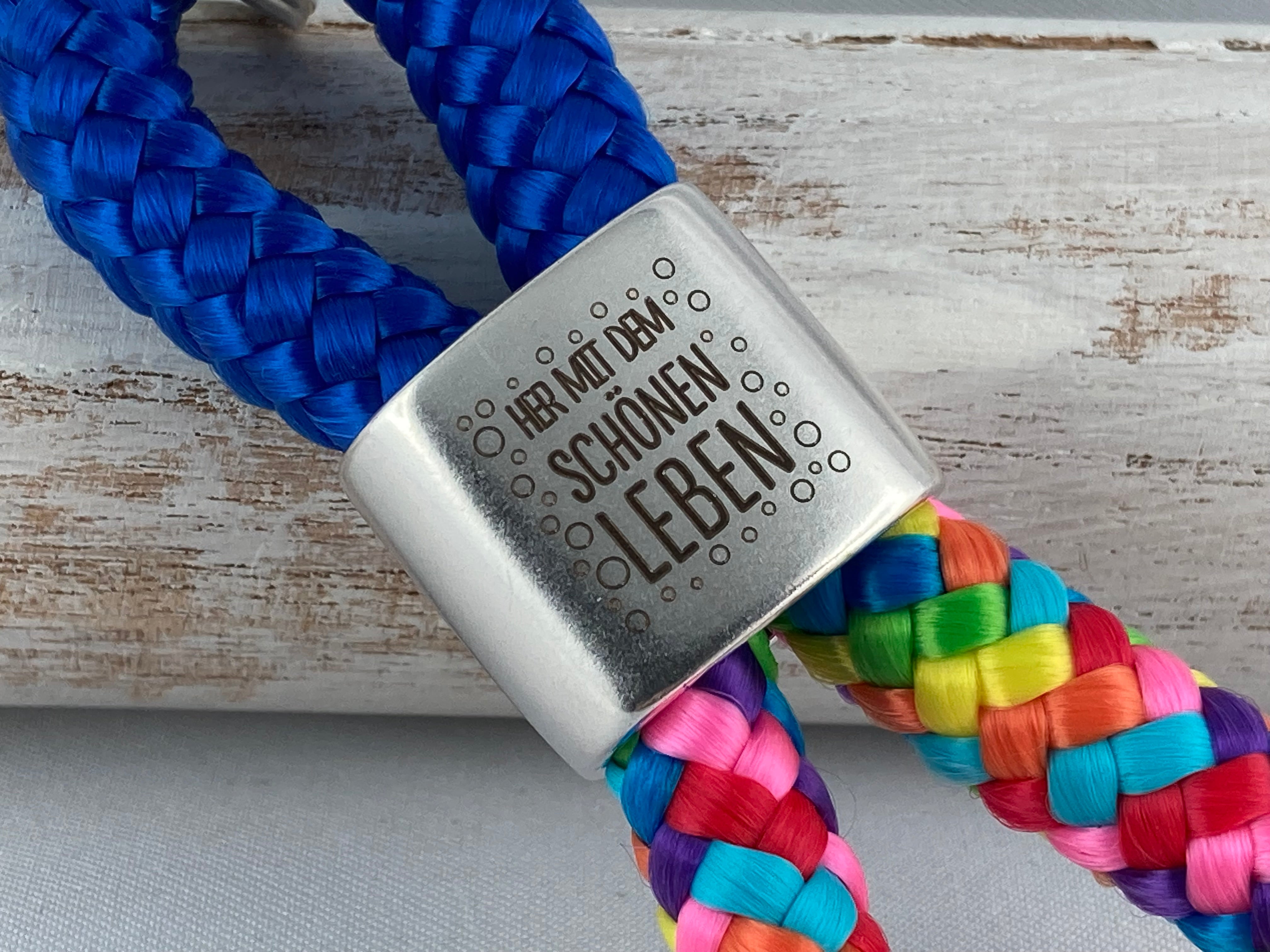 Schlüsselanhänger aus Segelseil mit versilbertem Zwischenstück mit Gravur "Her mit dem schönen Leben", blau/ regenbogen-mix