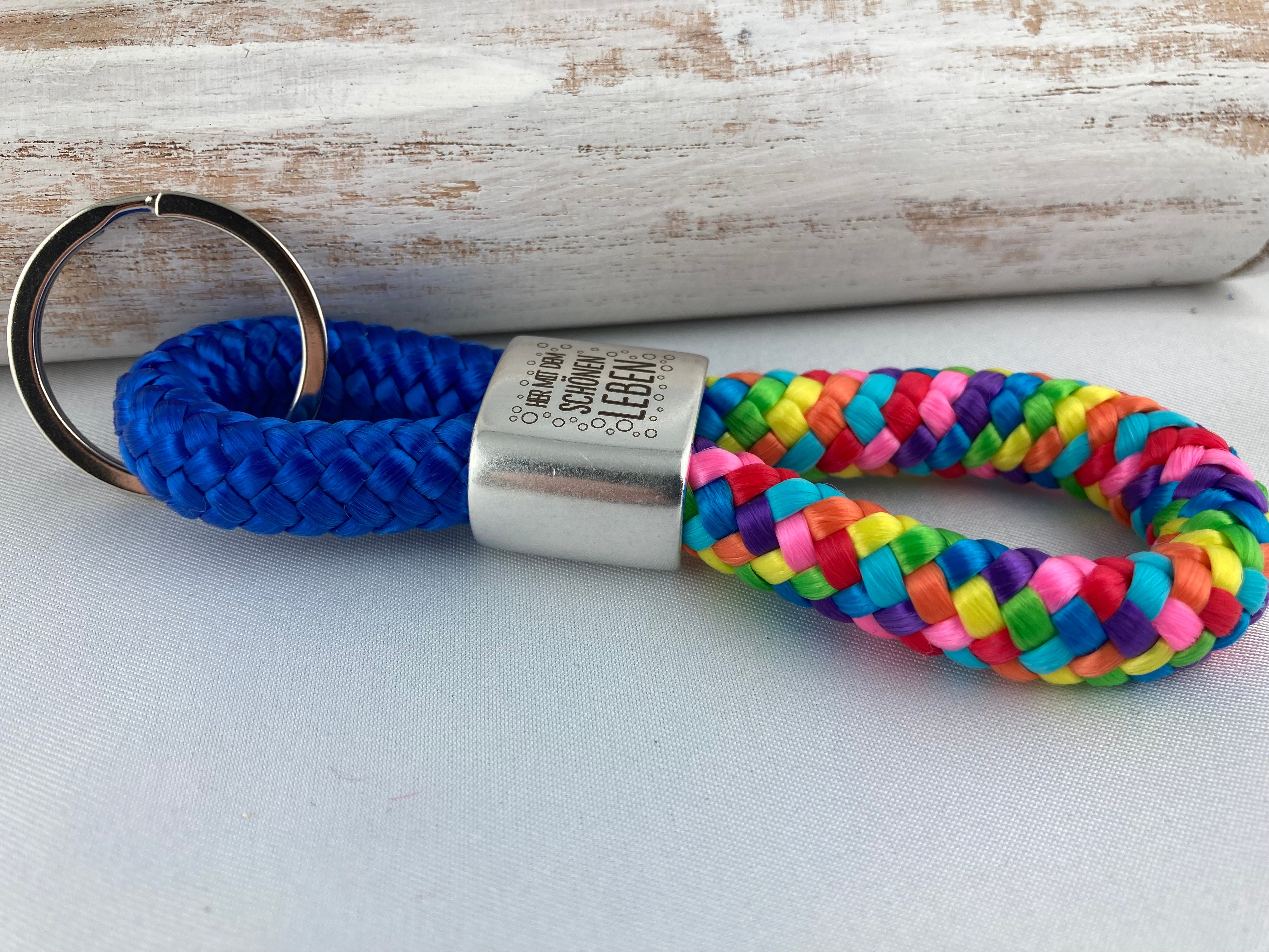 Schlüsselanhänger aus Segelseil mit versilbertem Zwischenstück mit Gravur "Her mit dem schönen Leben", blau/ regenbogen-mix