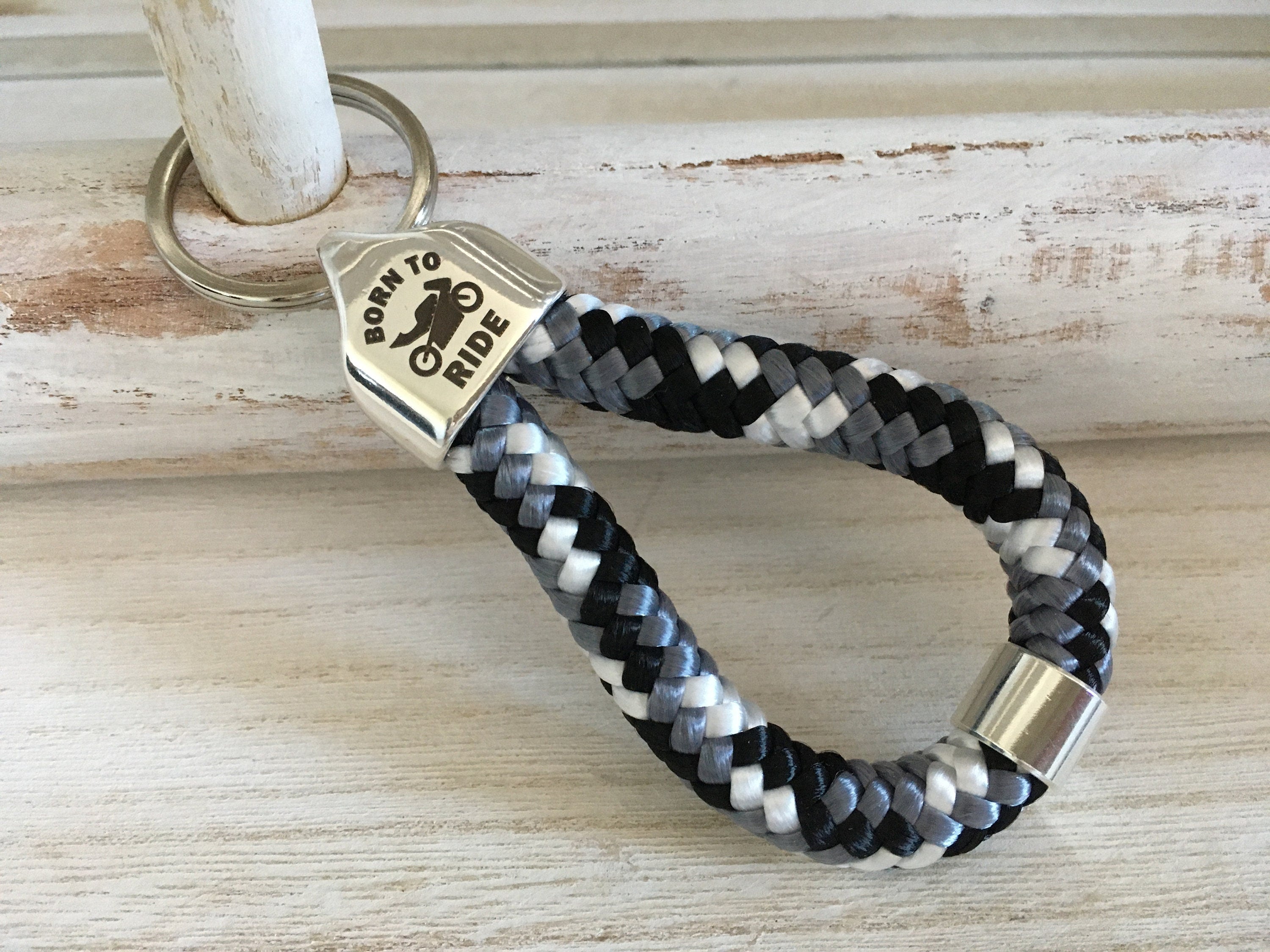 Schlüsselanhänger aus Segelseil mit versilberter Endkappe mit Gravur "Born to ride" und versilberter Schiebeperle, schwarz-weiß-grau-Mix