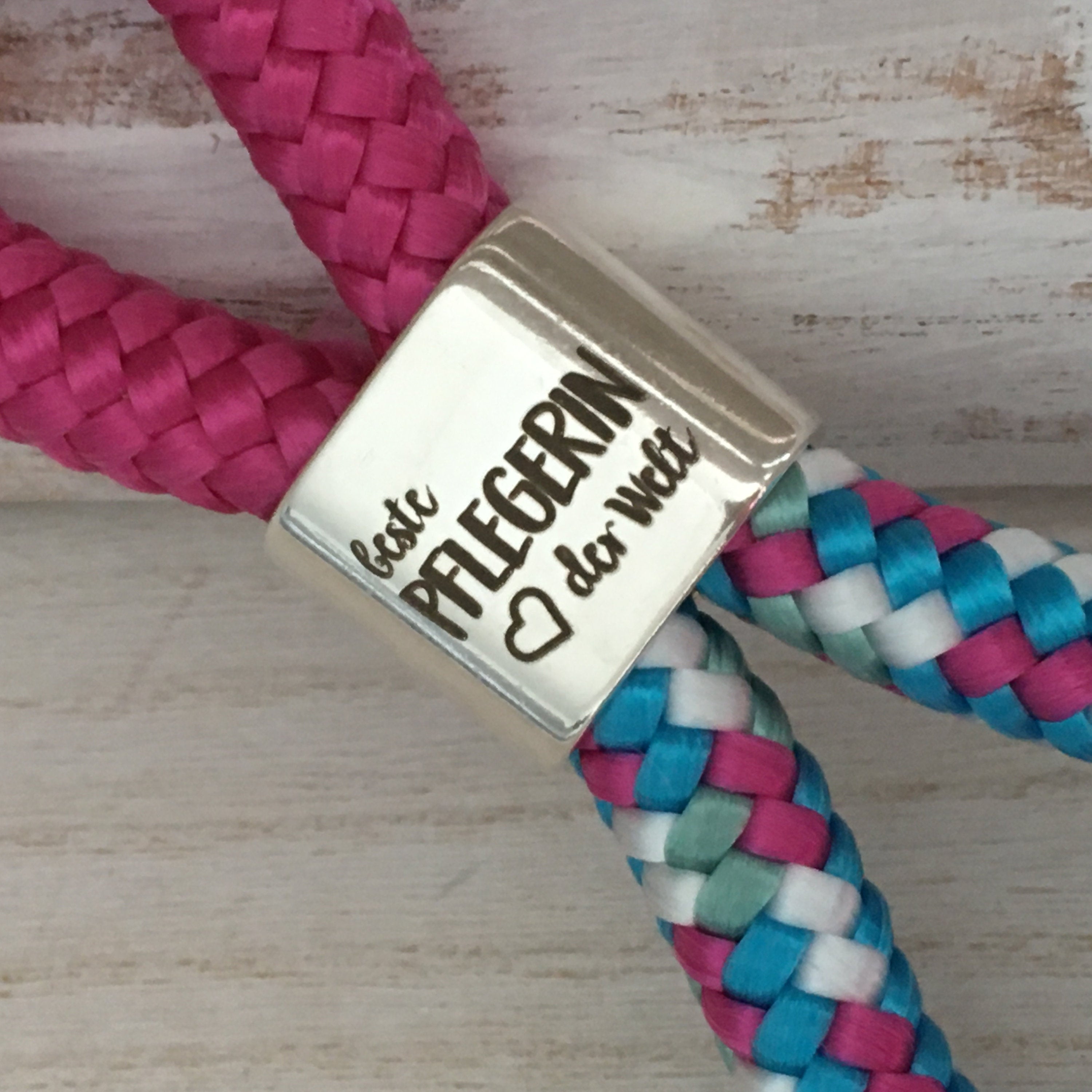 Schlüsselanhänger aus Segelseil mit versilbertem Zwischenstück mit Gravur "Beste Pflegerin der Welt" fuchsia/ weiß-blau-fuchsia-mix