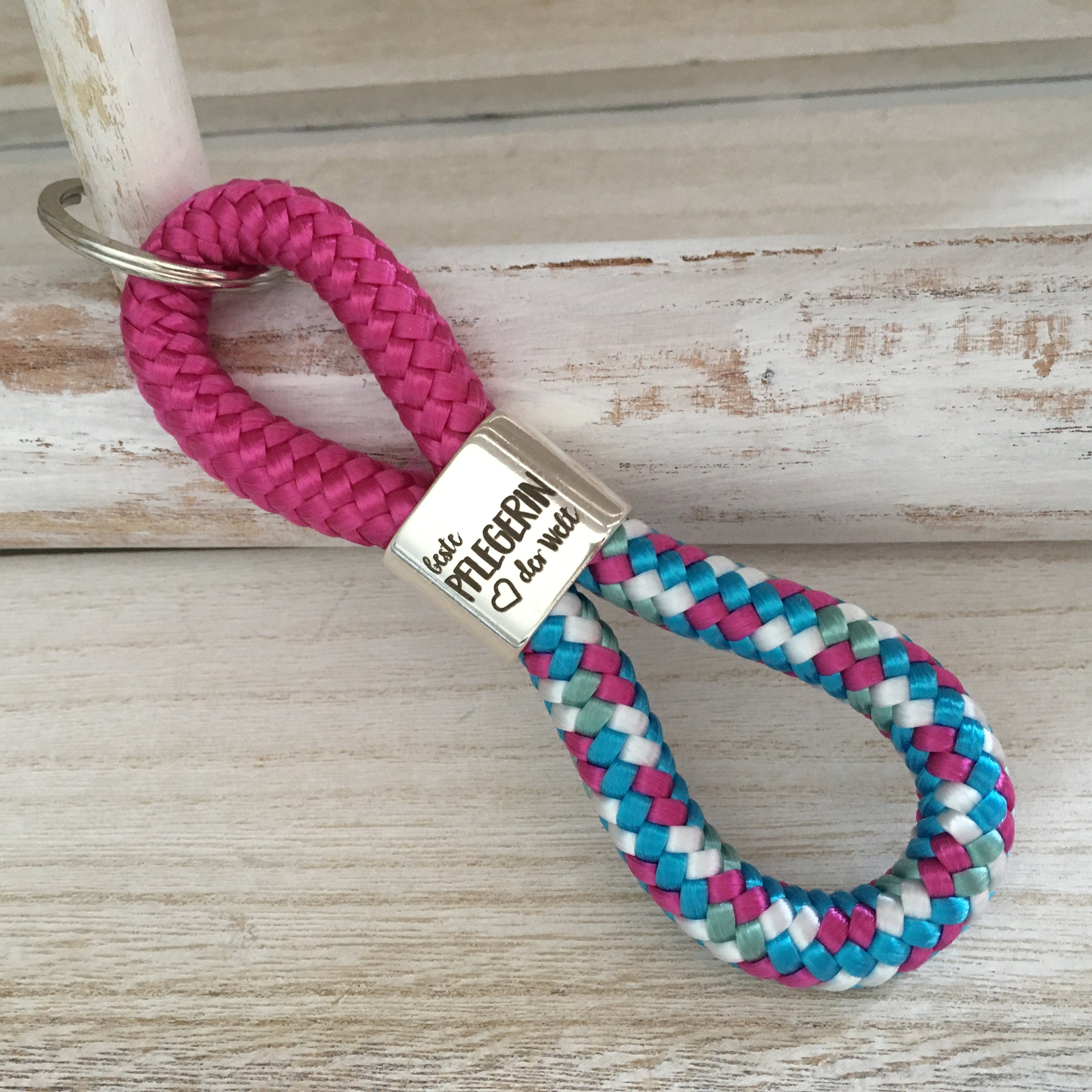 Schlüsselanhänger aus Segelseil mit versilbertem Zwischenstück mit Gravur "Beste Pflegerin der Welt" fuchsia/ weiß-blau-fuchsia-mix