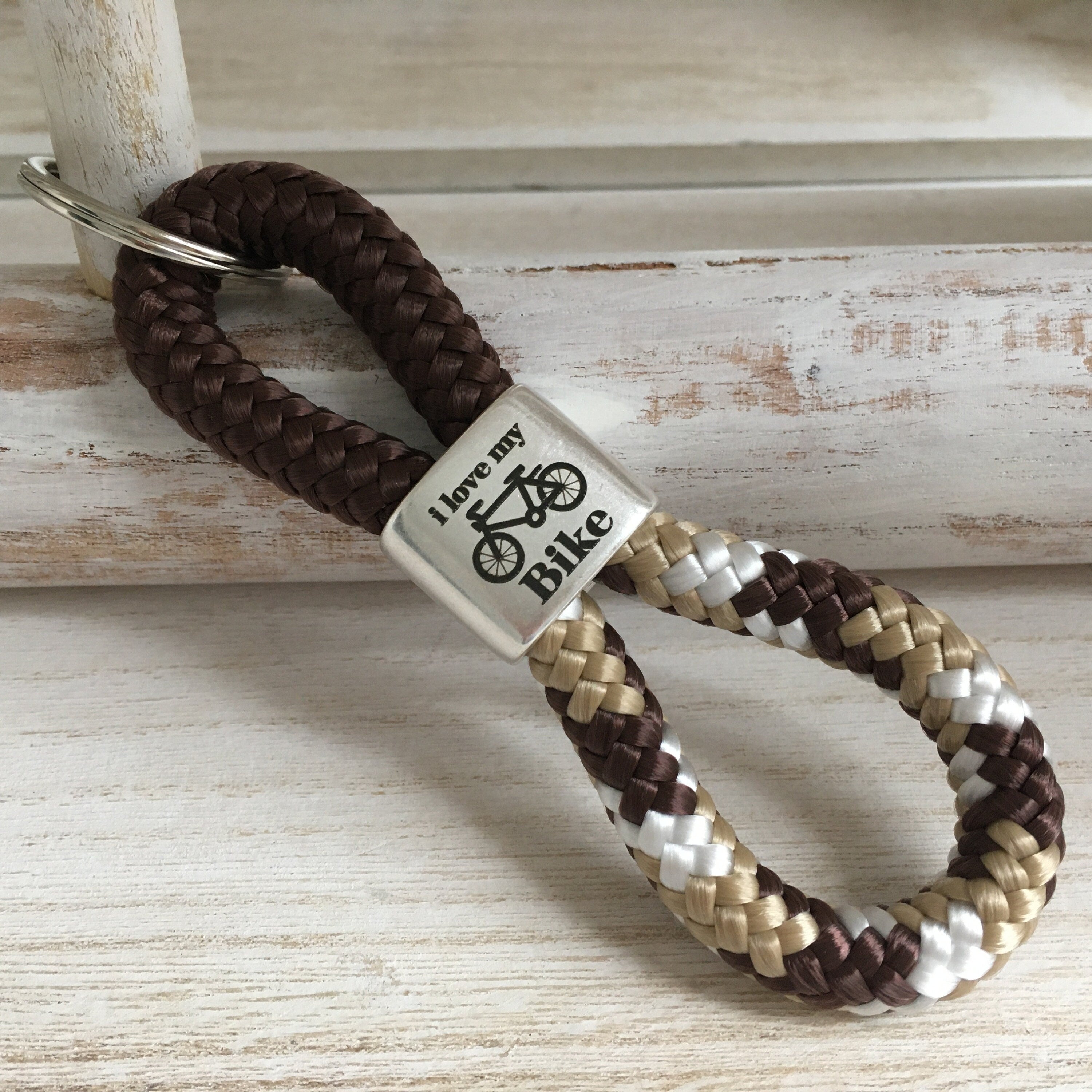Schlüsselanhänger aus Segelseil mit versilbertem Zwischenstück mit Gravur "i love my bike", braun/ braun-beige-weiß