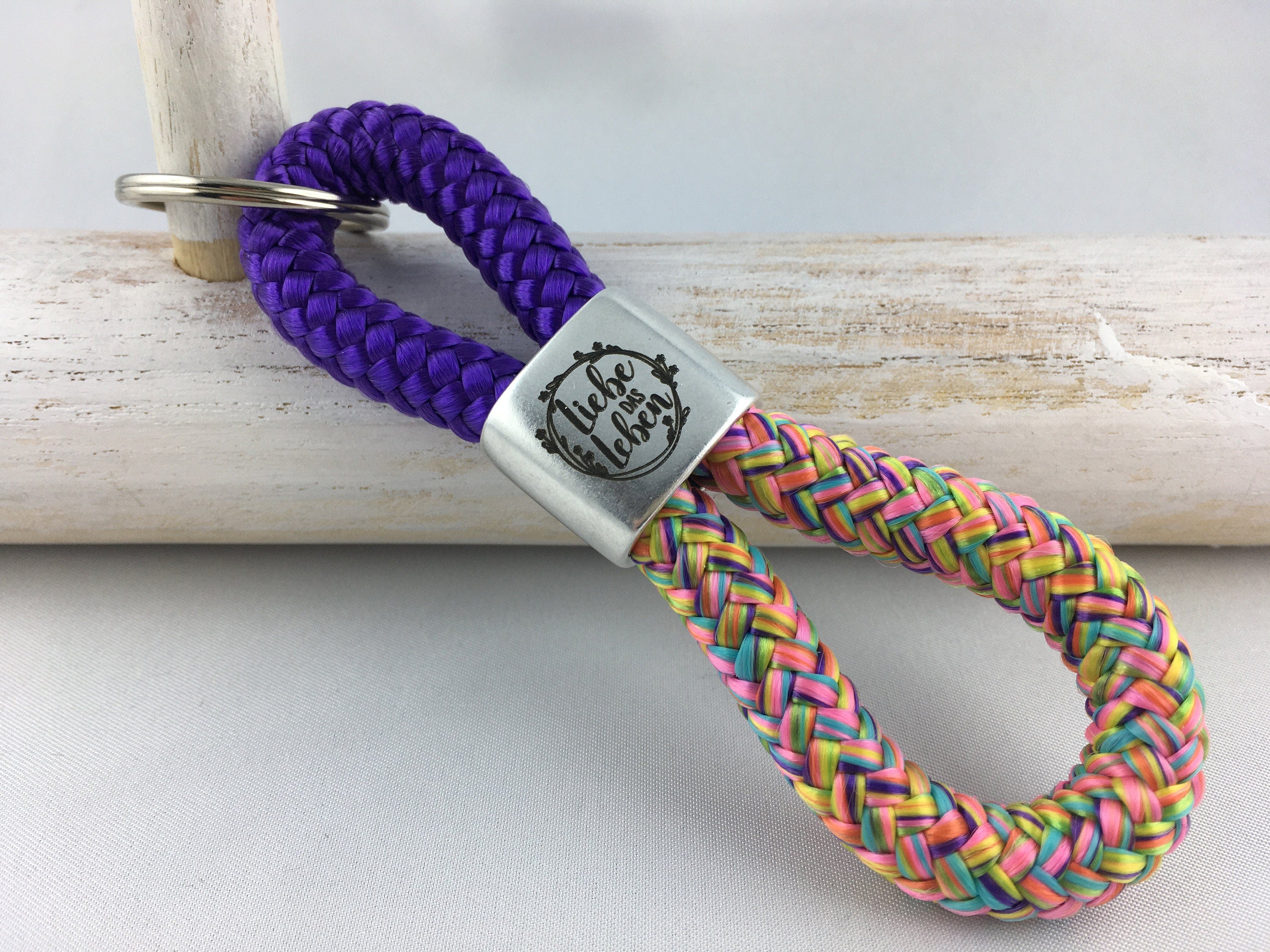 Schlüsselanhänger aus Segelseil mit versilbertem Zwischenstück mit Gravur "Liebe das Leben", lila/ flowerpower