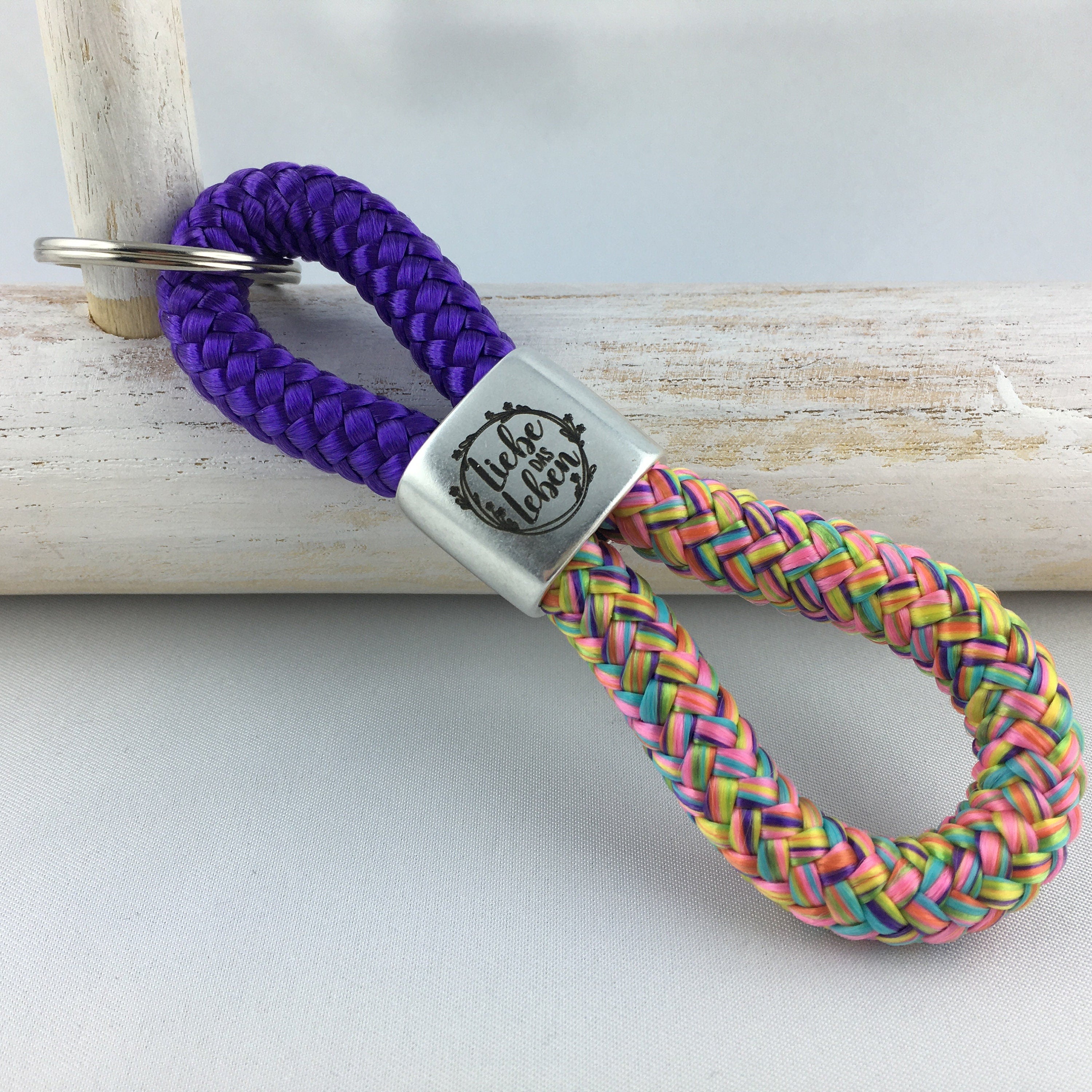 Schlüsselanhänger aus Segelseil mit versilbertem Zwischenstück mit Gravur "Liebe das Leben", lila/ flowerpower