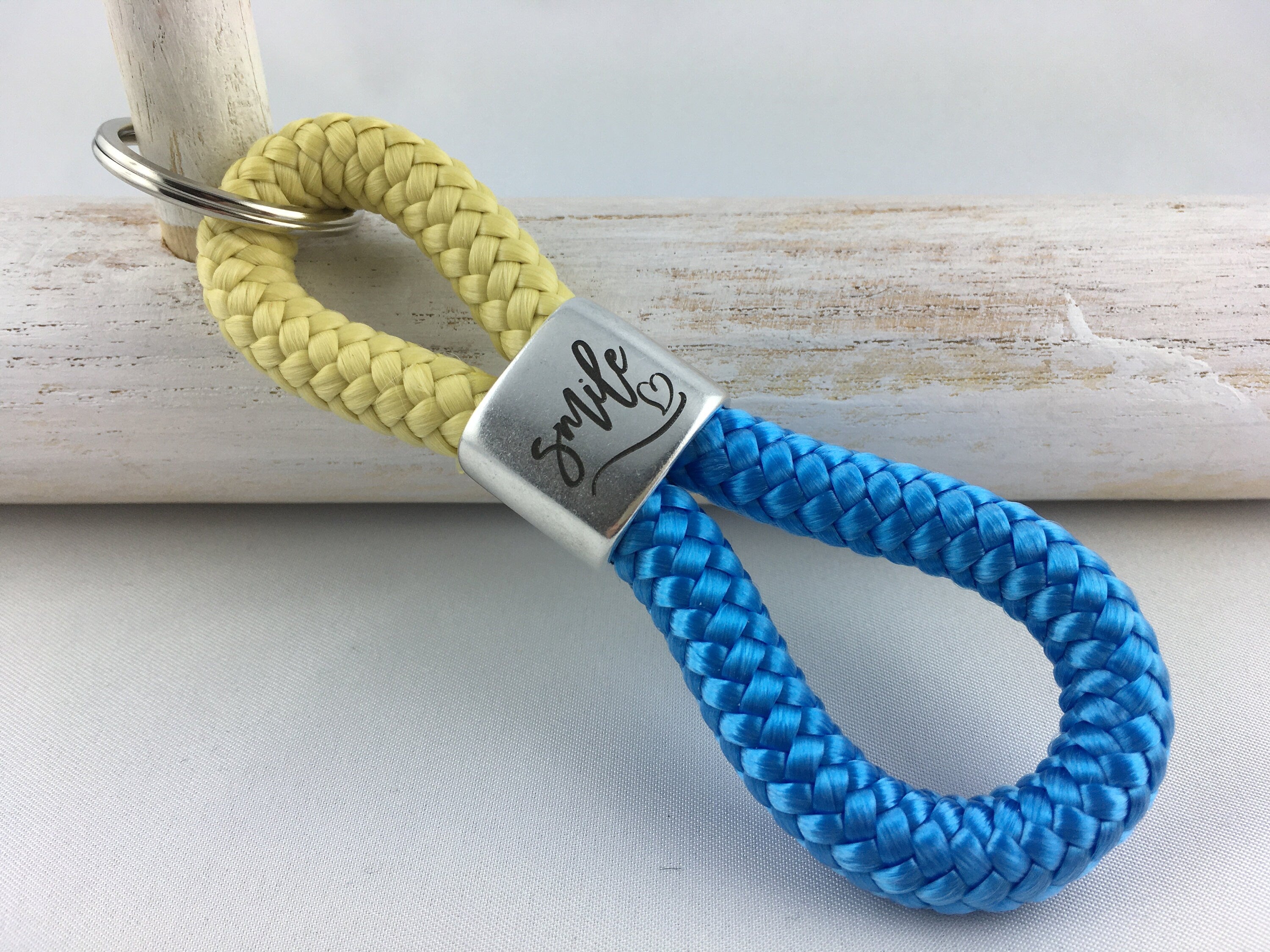 Schlüsselanhänger aus Segelseil mit versilbertem Zwischenstück mit Gravur "smile", pastellgelb/ himmelblau