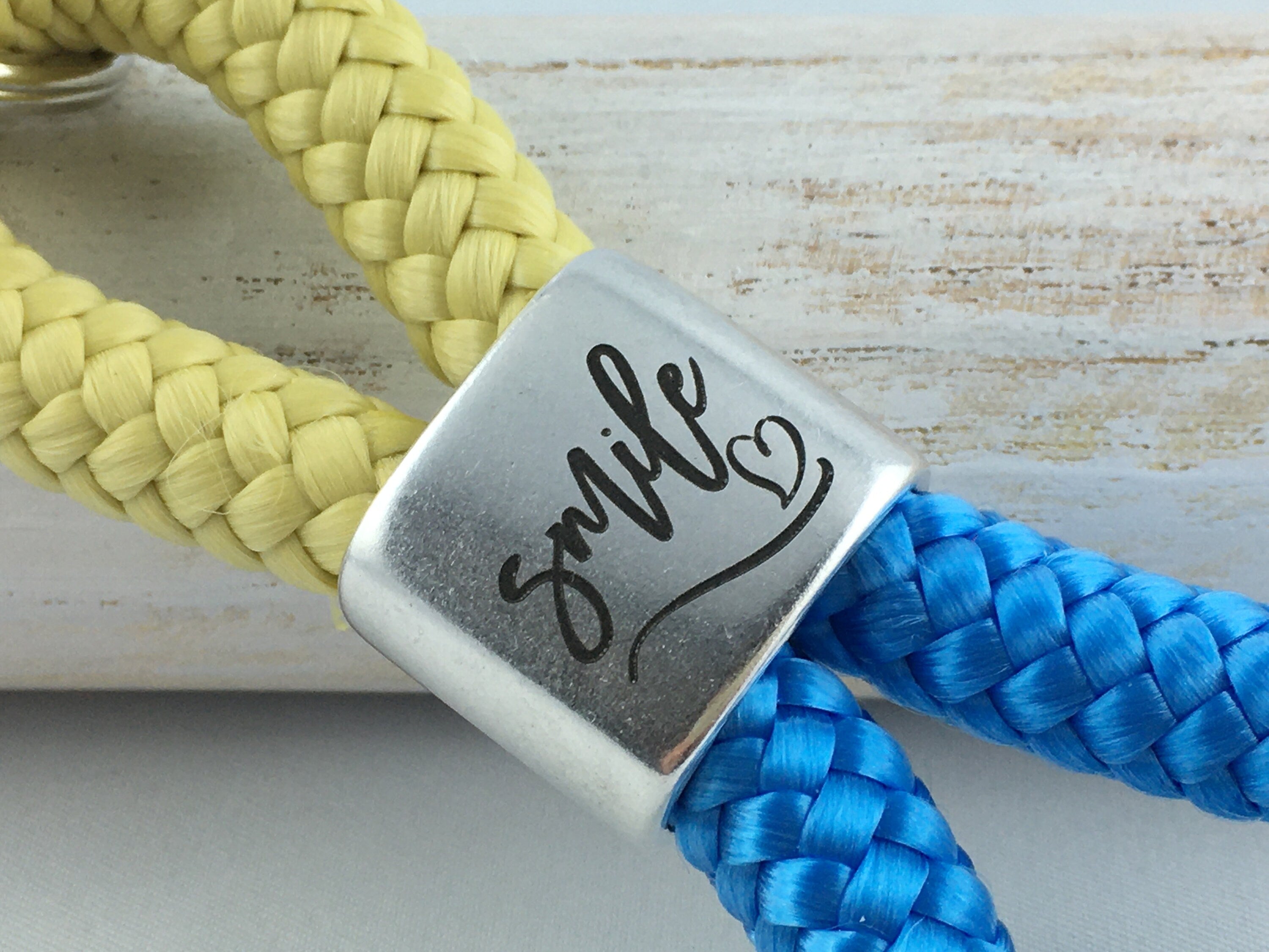 Schlüsselanhänger aus Segelseil mit versilbertem Zwischenstück mit Gravur "smile", pastellgelb/ himmelblau