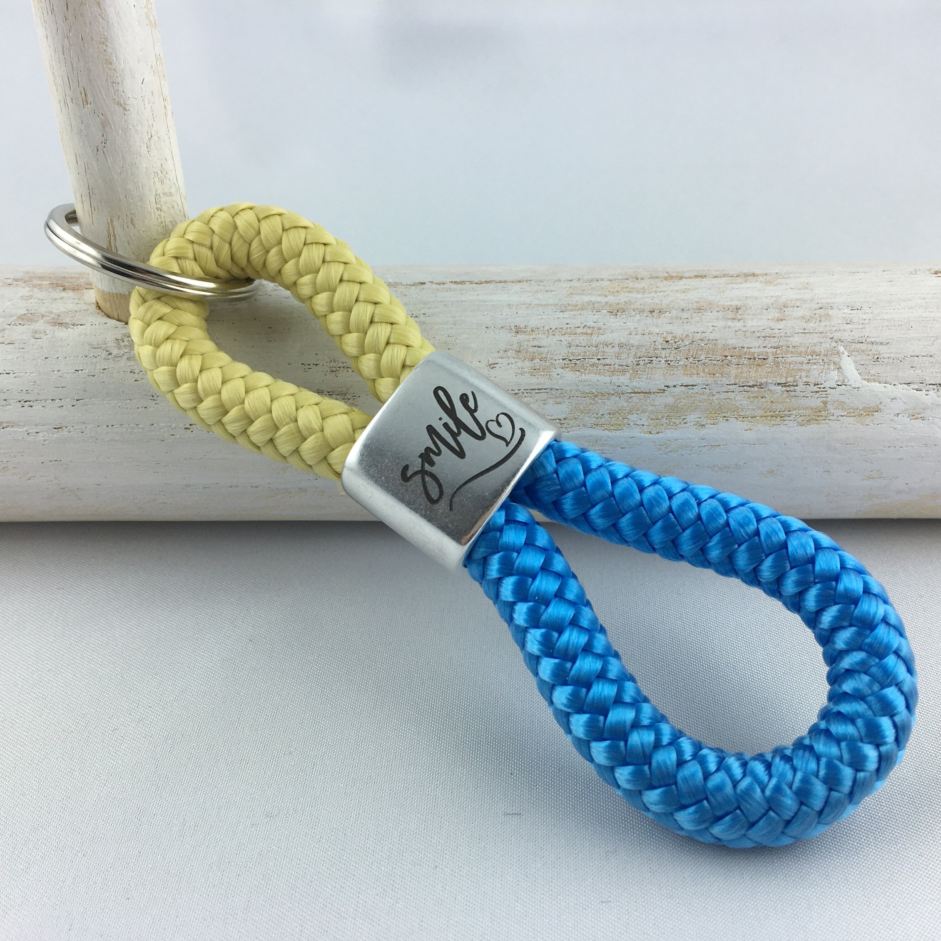 Schlüsselanhänger aus Segelseil mit versilbertem Zwischenstück mit Gravur "smile", pastellgelb/ himmelblau