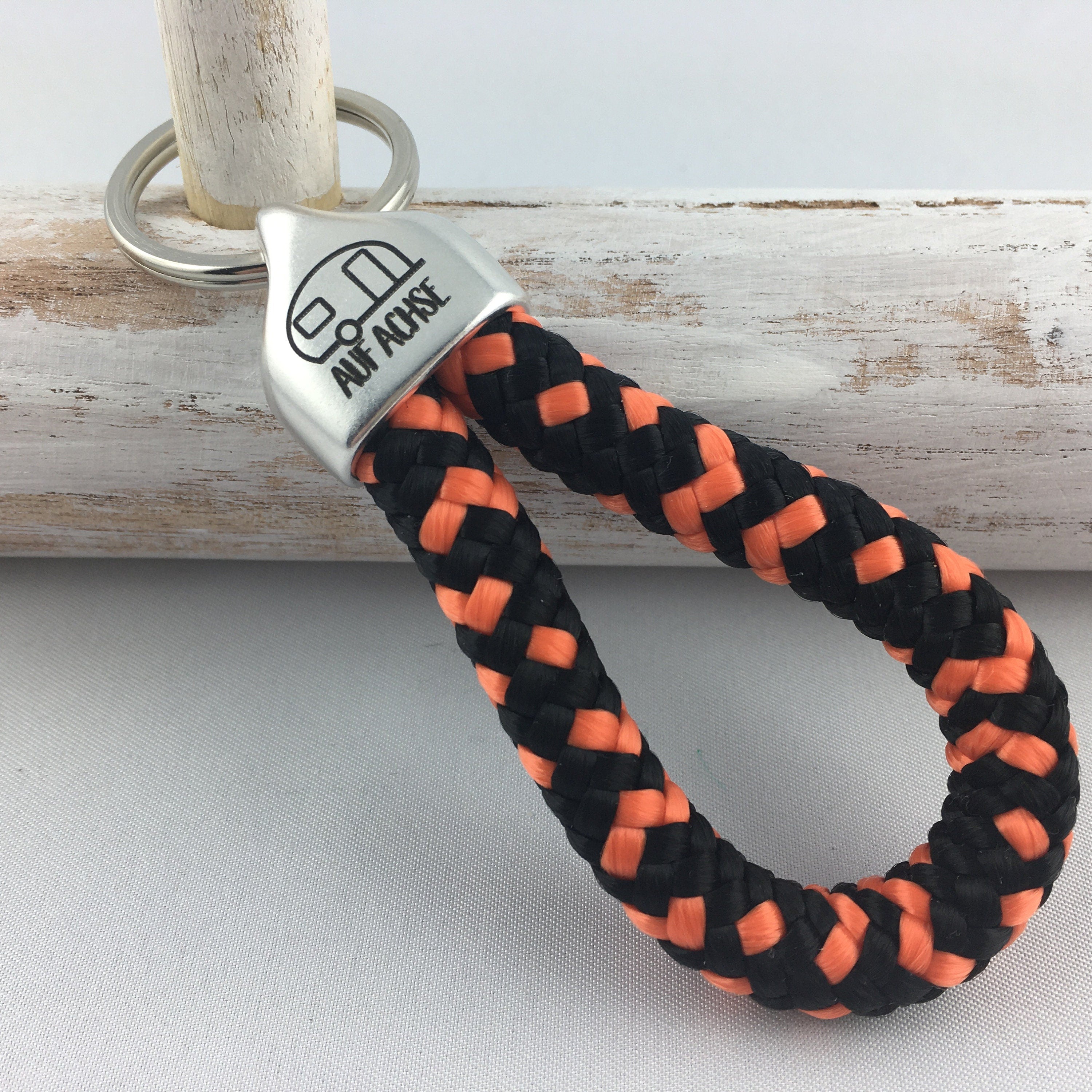 Schlüsselanhänger aus Segelseil mit versilberter Endkappe mit Gravur "Auf Achse" (Wohnwagen), schwarz-orange