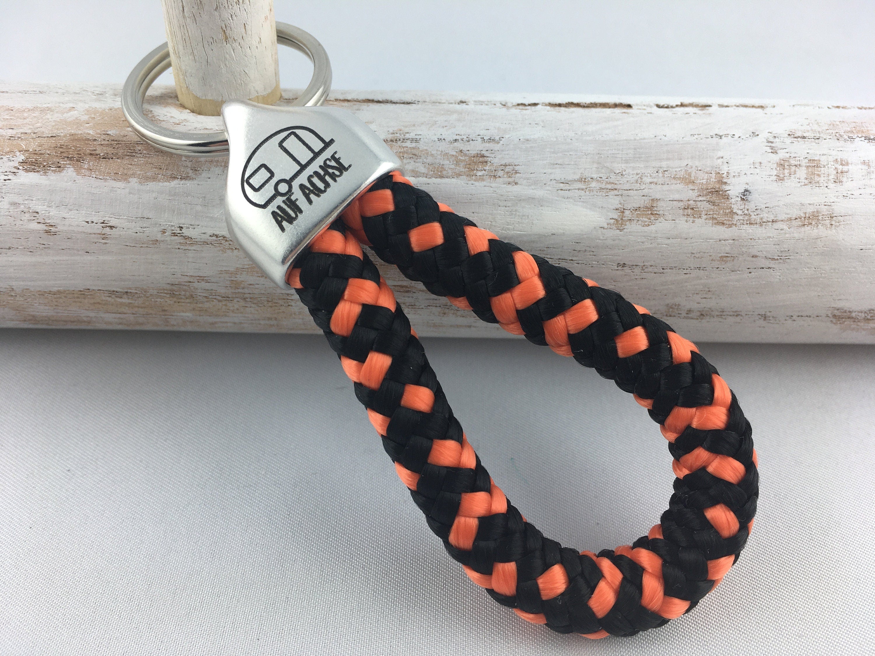 Schlüsselanhänger aus Segelseil mit versilberter Endkappe mit Gravur "Auf Achse" (Wohnwagen), schwarz-orange