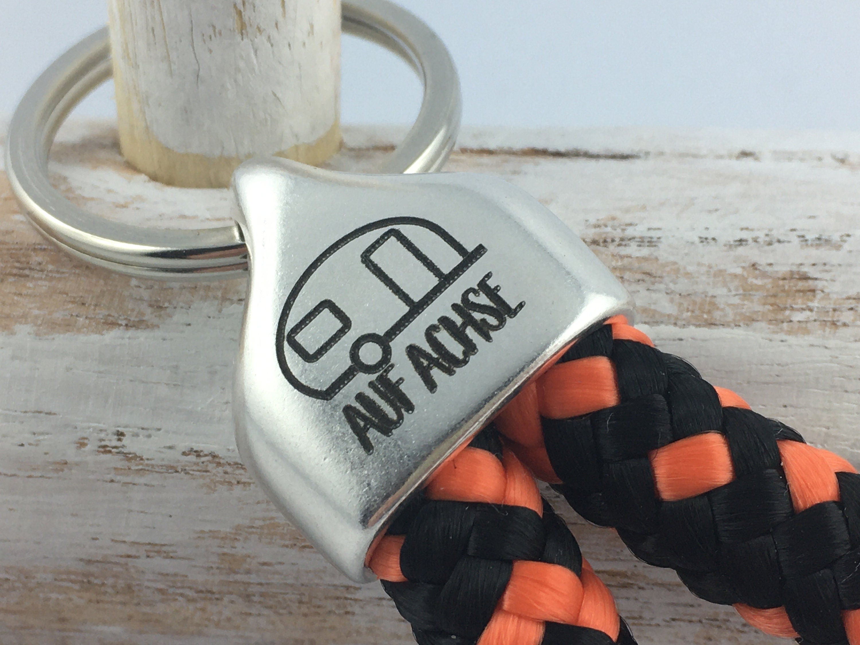 Schlüsselanhänger aus Segelseil mit versilberter Endkappe mit Gravur "Auf Achse" (Wohnwagen), schwarz-orange