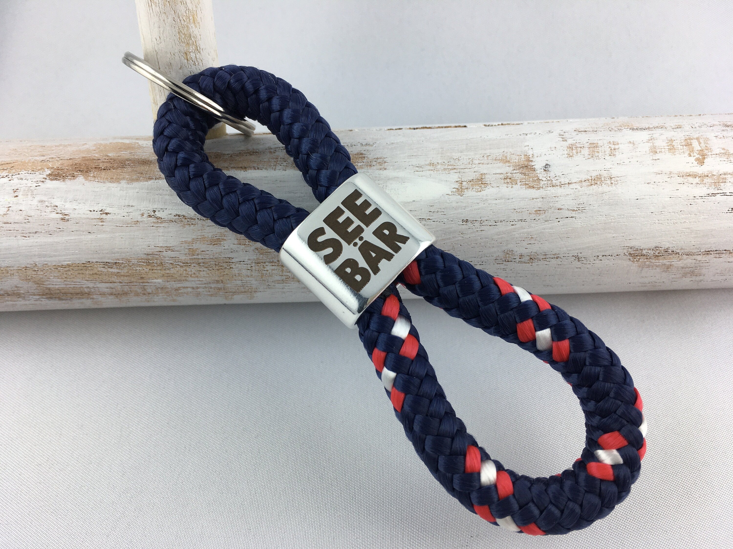 Schlüsselanhänger aus Segelseil mit versilbertem Zwischenstück mit Gravur "Seebär", maritimer Schlüsselanhänger, dunkelblau/ blau-rot-weiß