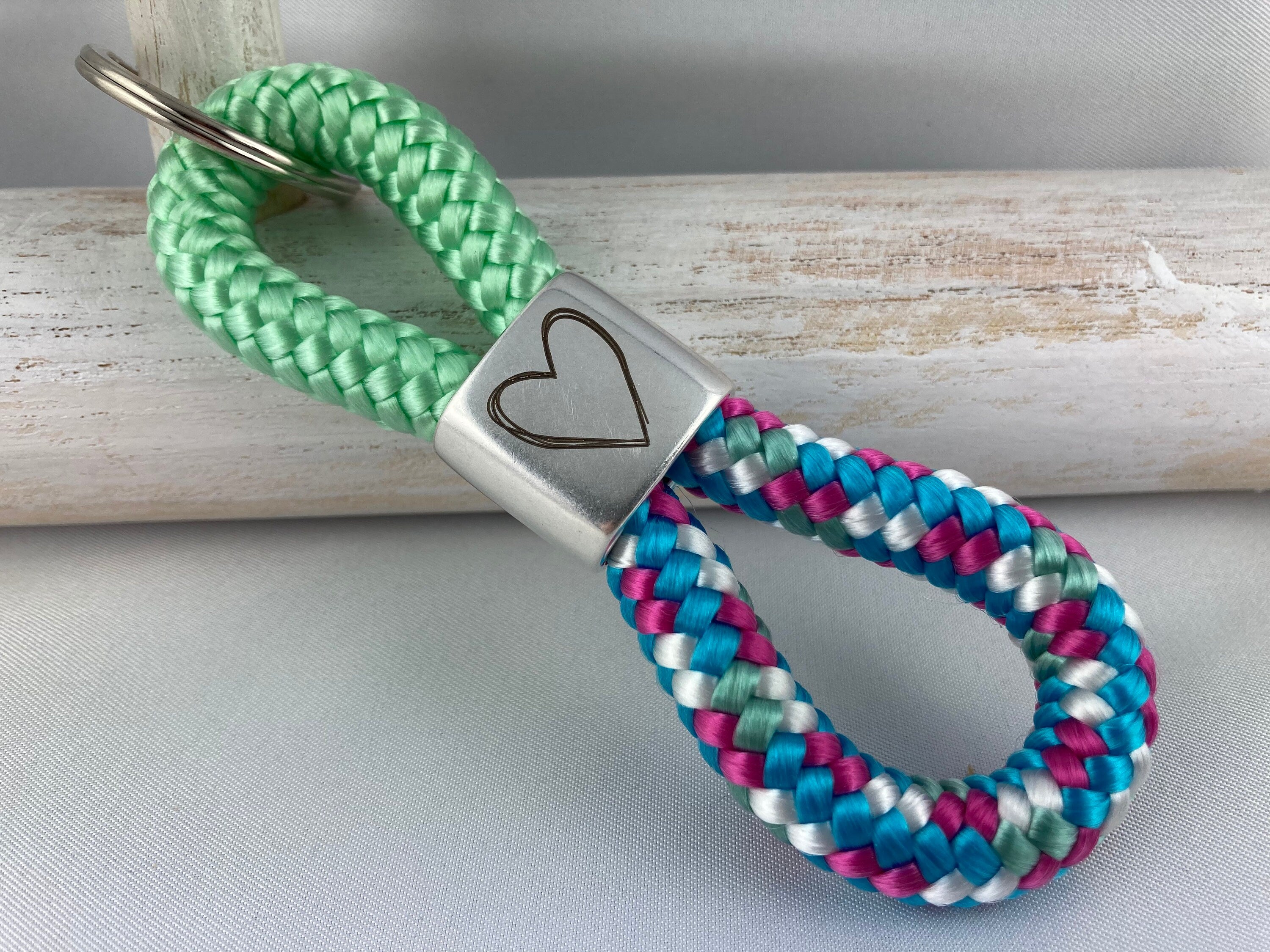 Schlüsselanhänger aus Segelseil mit versilbertem Zwischenstück mit Gravur "Herz", pistazie/ weiß-blau-fuchsia-mix