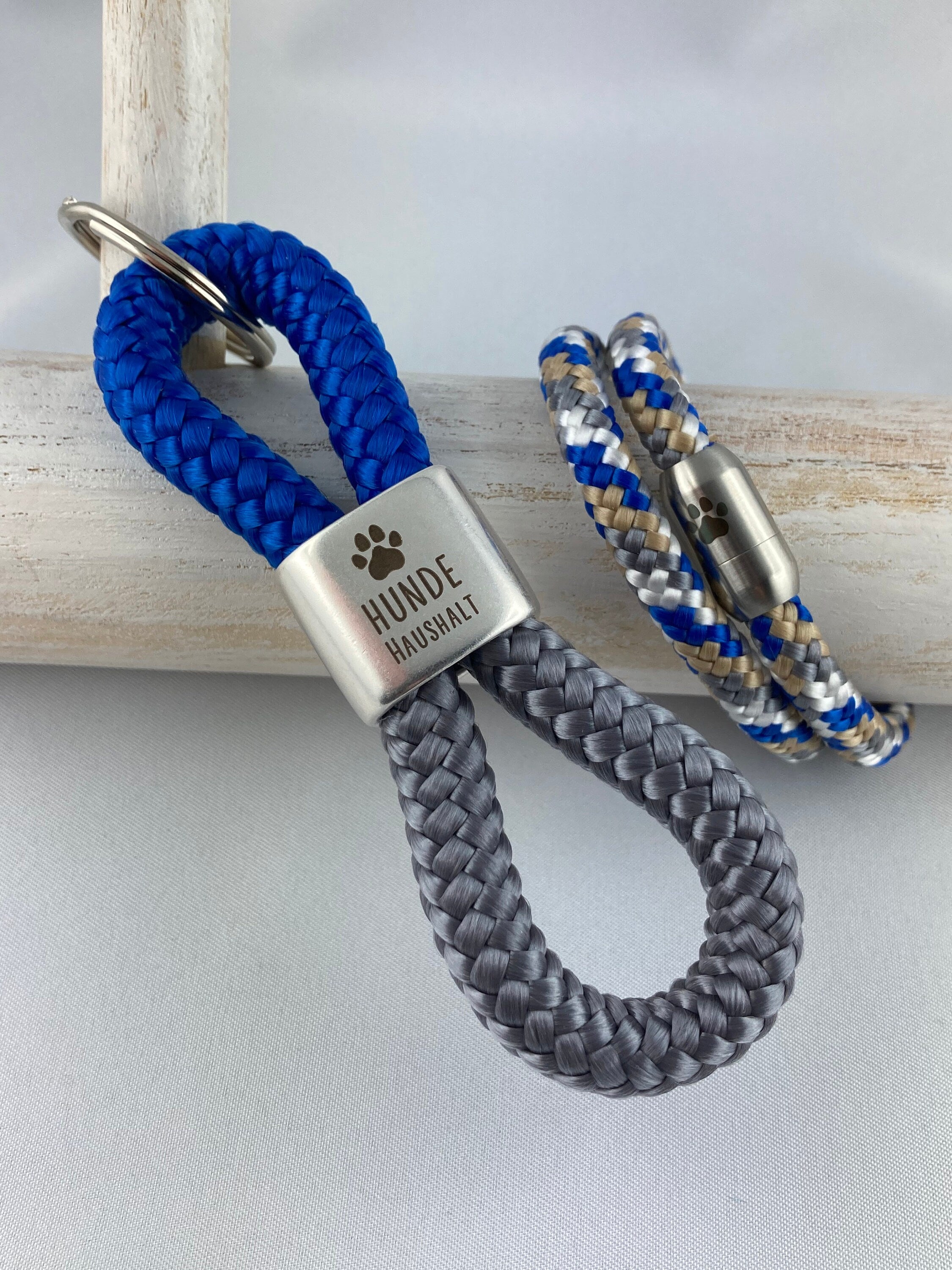 Set Schlüsselanhänger mit versilbertem Zwischenstück mit Gravur "Hundehaushalt" und Armband mit Magnetverschluß aus Edelstahl mit Pfote