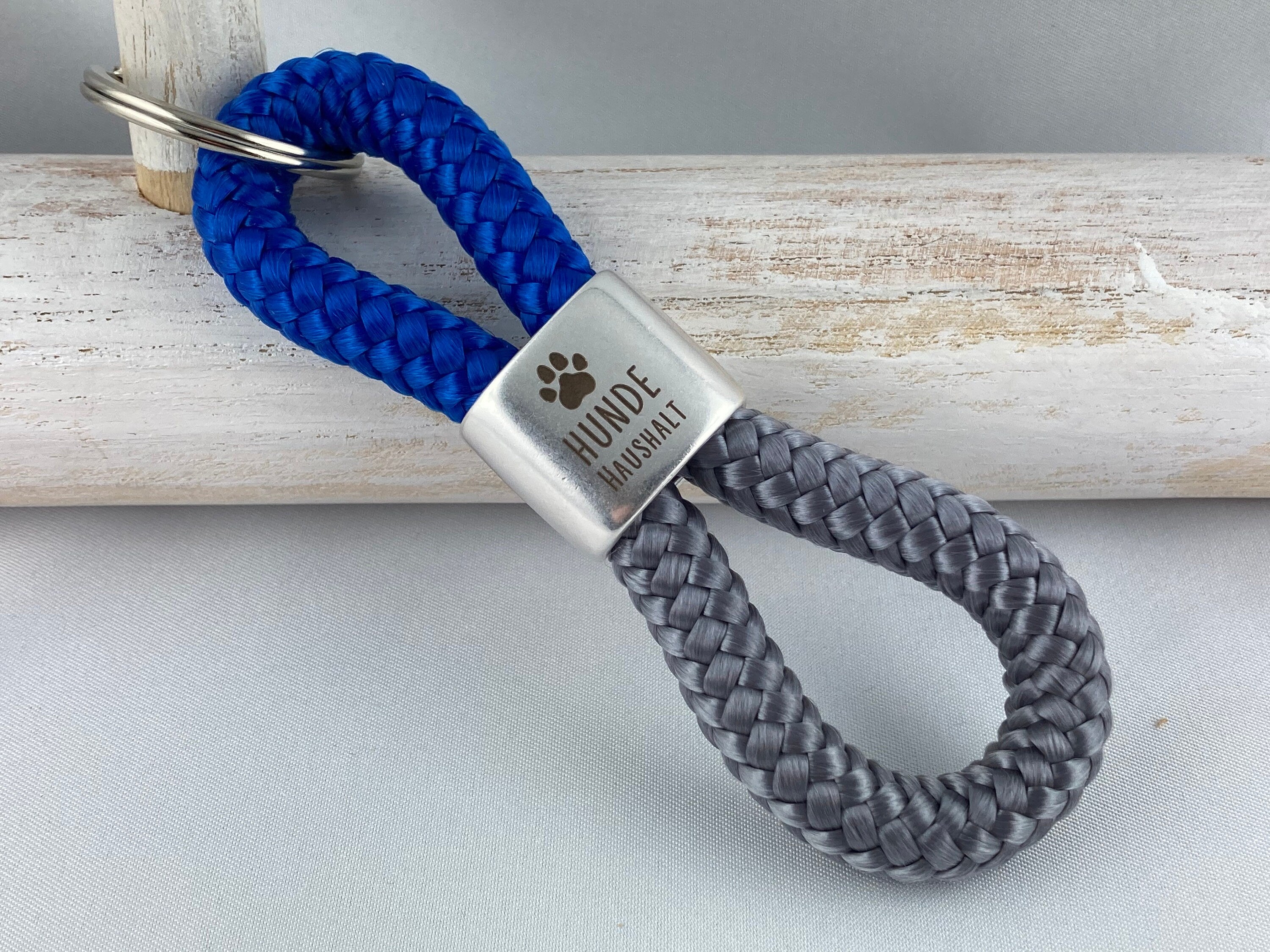 Set Schlüsselanhänger mit versilbertem Zwischenstück mit Gravur "Hundehaushalt" und Armband mit Magnetverschluß aus Edelstahl mit Pfote