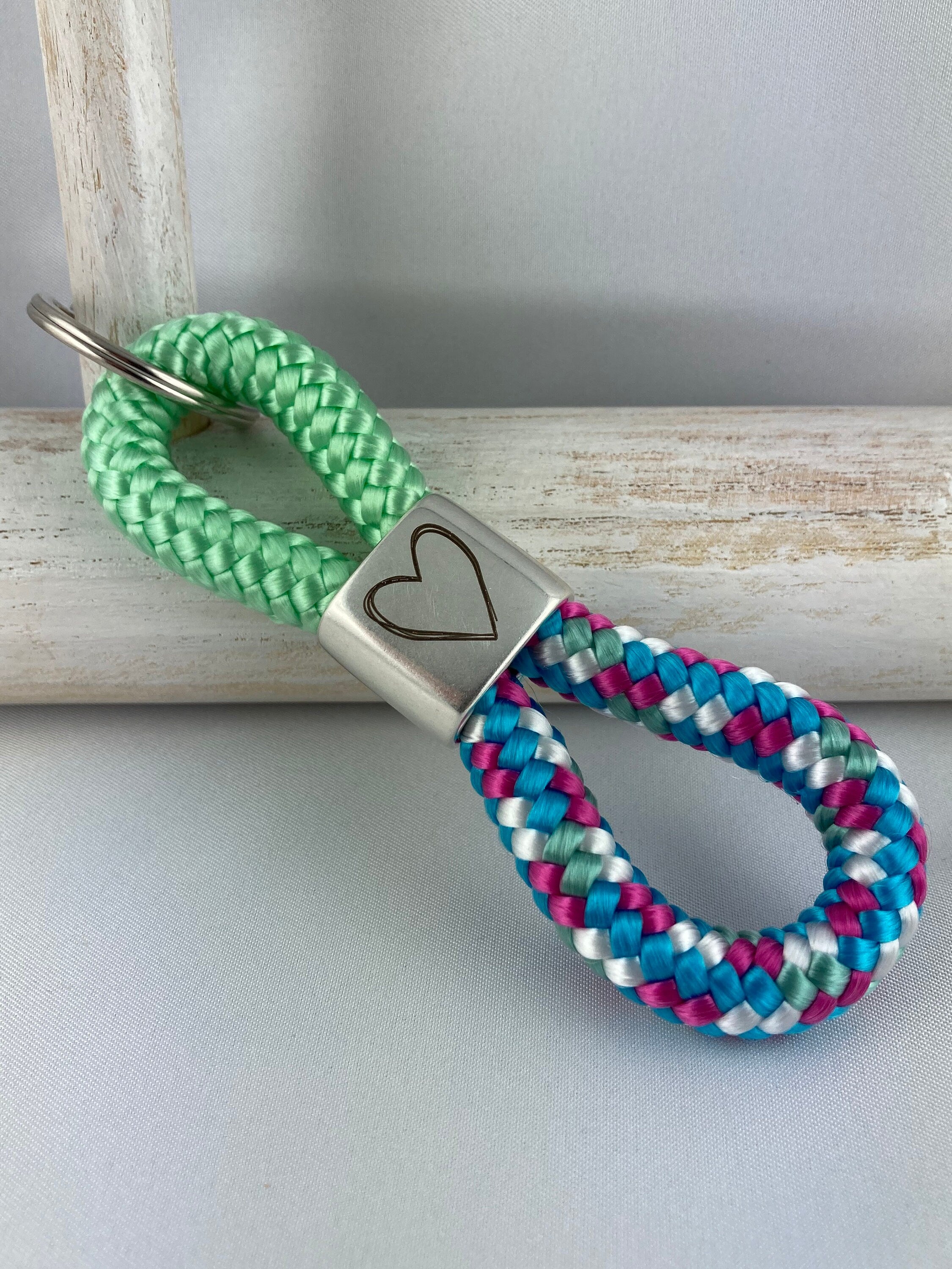 Schlüsselanhänger aus Segelseil mit versilbertem Zwischenstück mit Gravur "Herz", pistazie/ weiß-blau-fuchsia-mix