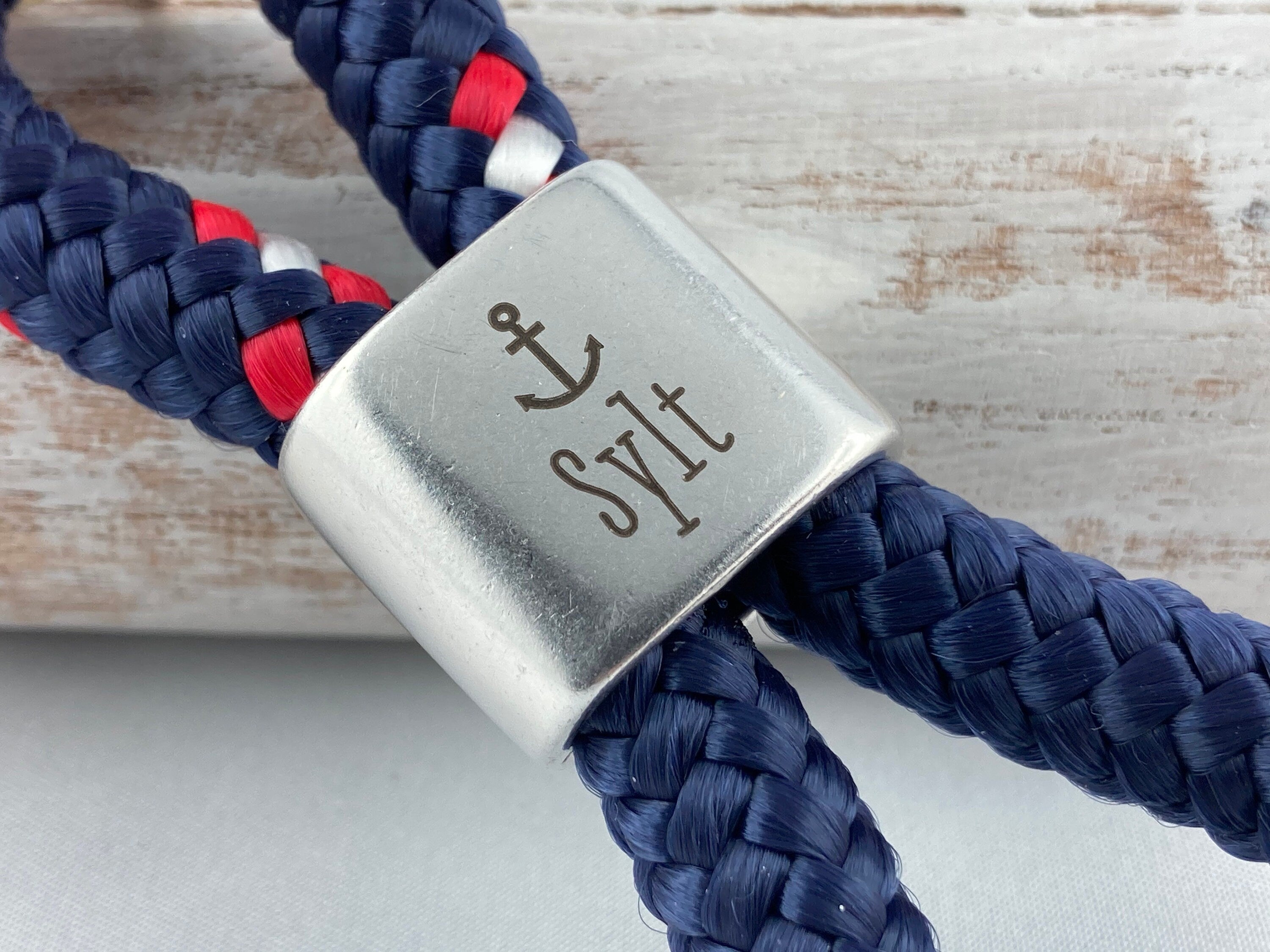 Schlüsselanhänger aus Segelseil mit versilbertem Zwischenstück mit Gravur "Sylt", blau-rot-weiß/ dunkelblau