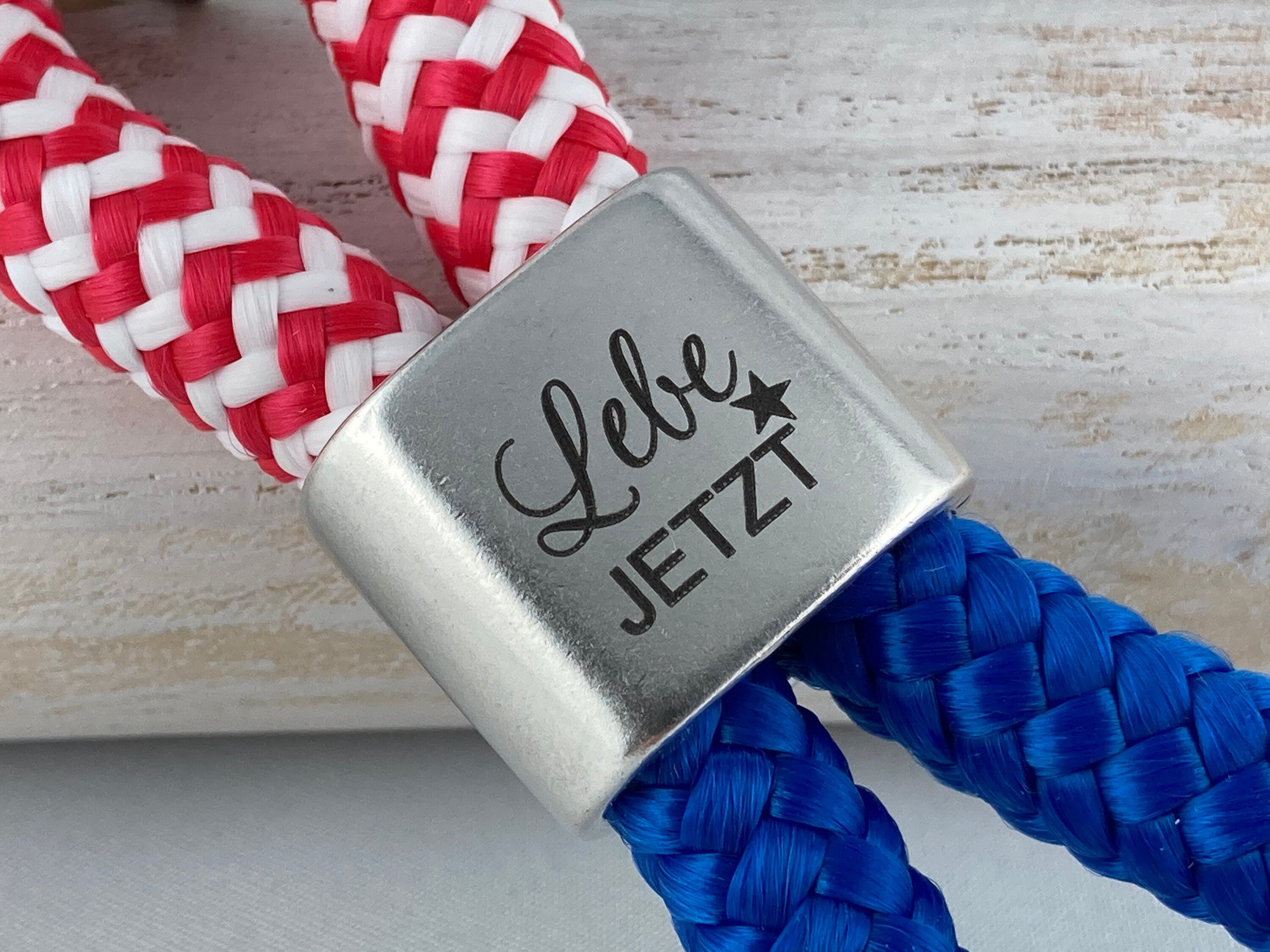Schlüsselanhänger aus Segelseil mit versilbertem Zwischenstück mit Gravur "Lebe jetzt", rot-weiß/ blau