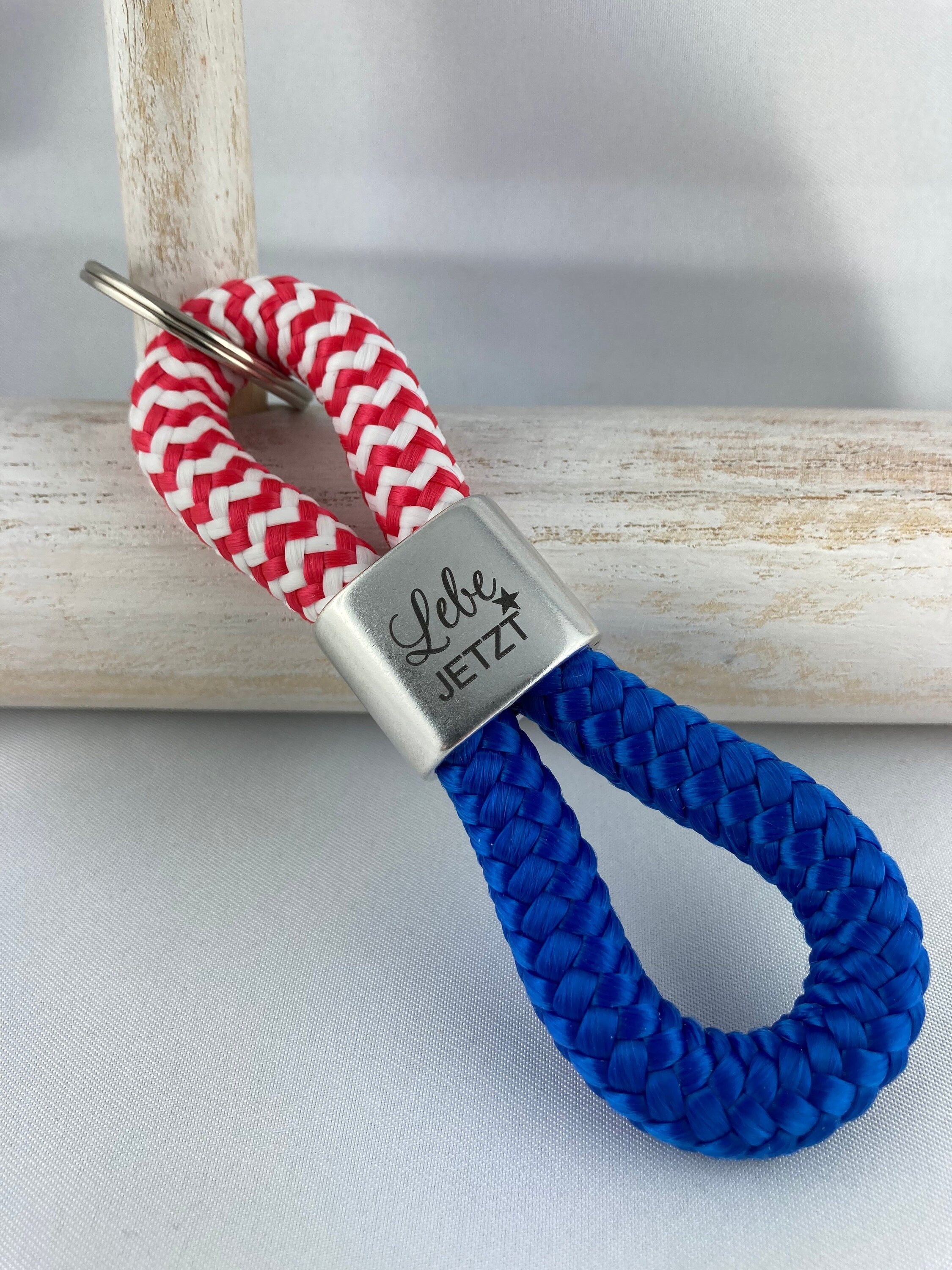 Schlüsselanhänger aus Segelseil mit versilbertem Zwischenstück mit Gravur "Lebe jetzt", rot-weiß/ blau