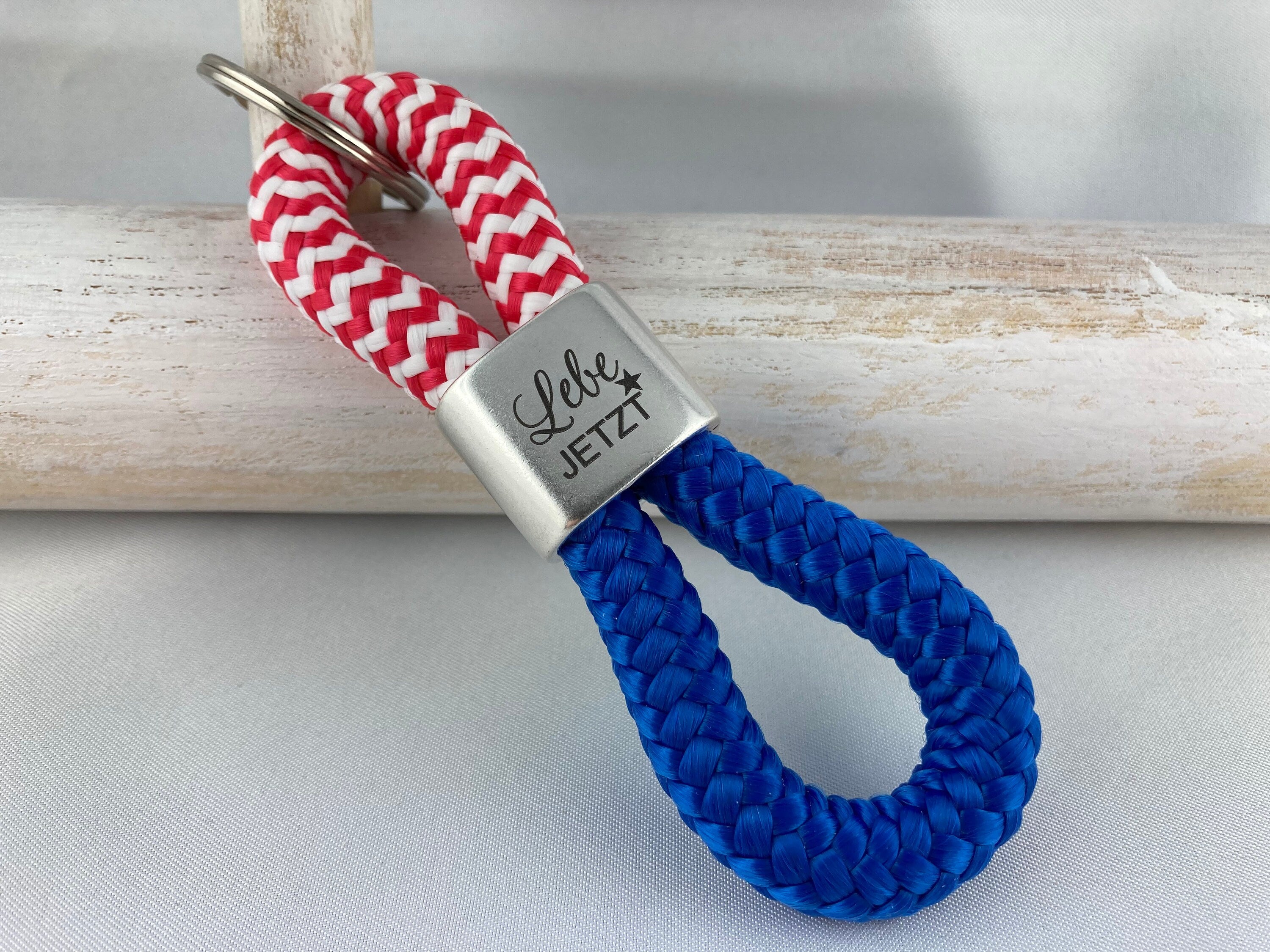 Schlüsselanhänger aus Segelseil mit versilbertem Zwischenstück mit Gravur "Lebe jetzt", rot-weiß/ blau