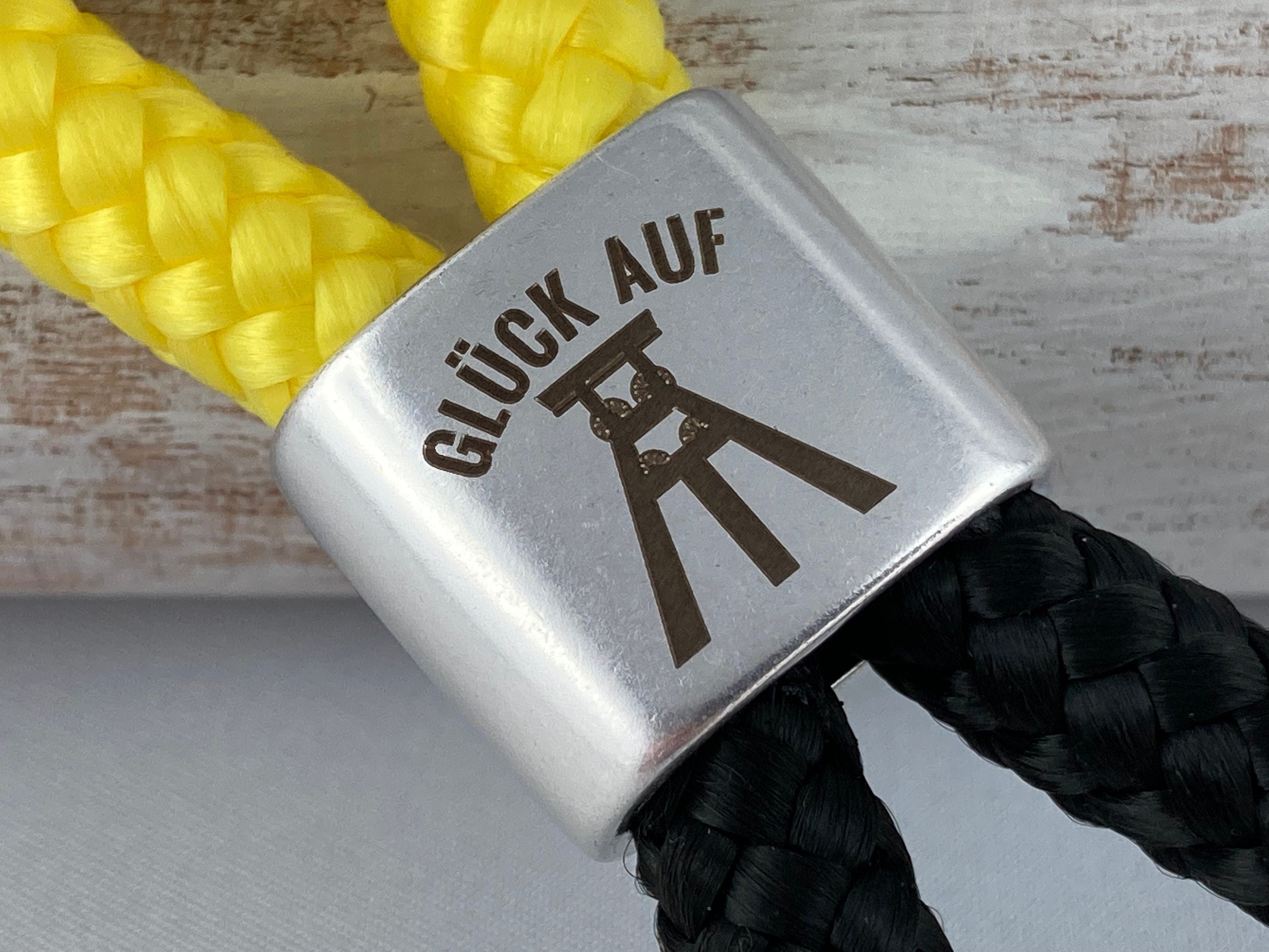 Schlüsselanhänger aus Segelseil mit versilbertem Zwischenstück mit Gravur "Glück auf", gelb/ schwarz