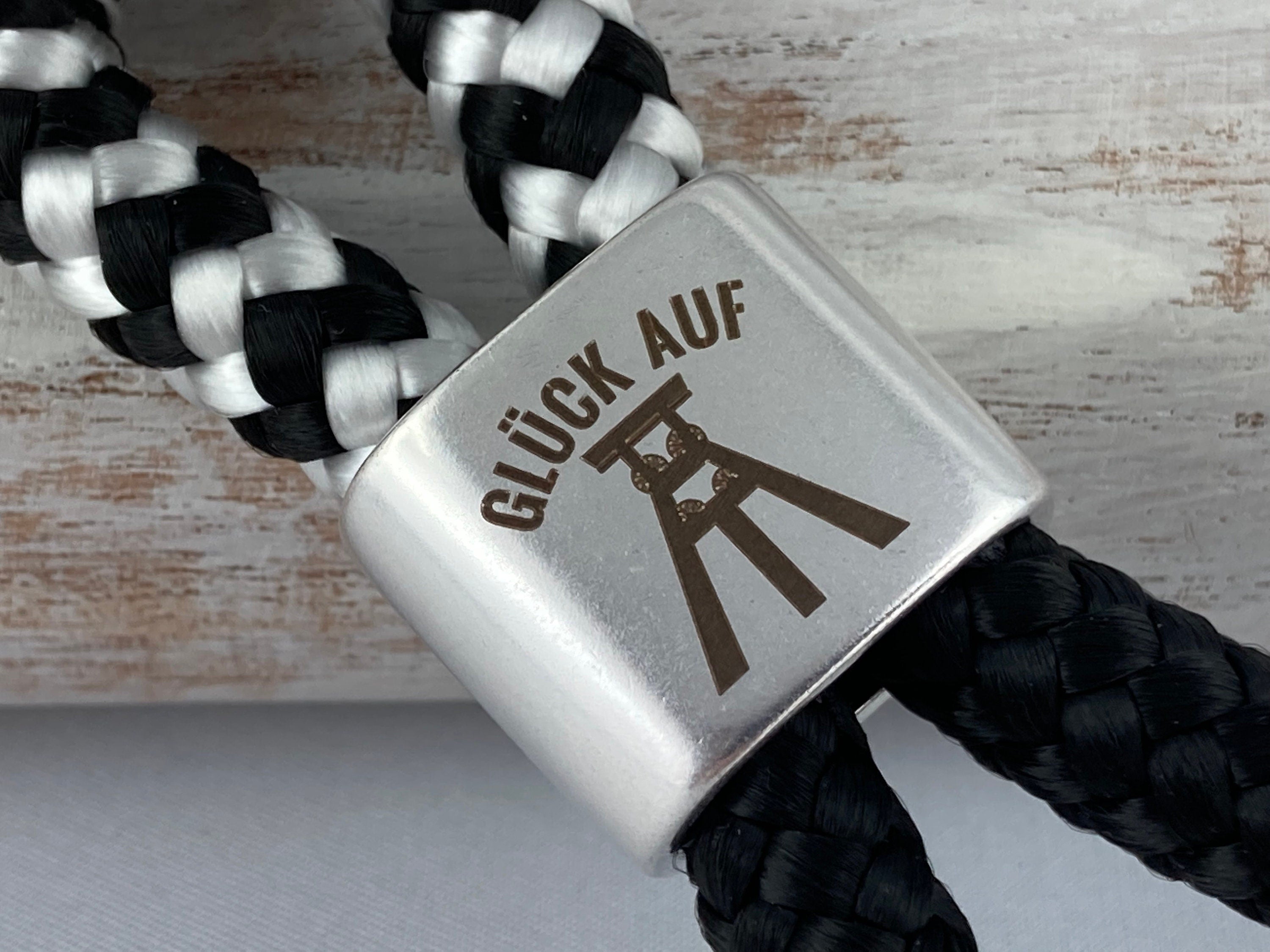 Schlüsselanhänger aus Segelseil mit versilbertem Zwischenstück mit Gravur "Glück auf", schwarz-weiß/ schwarz