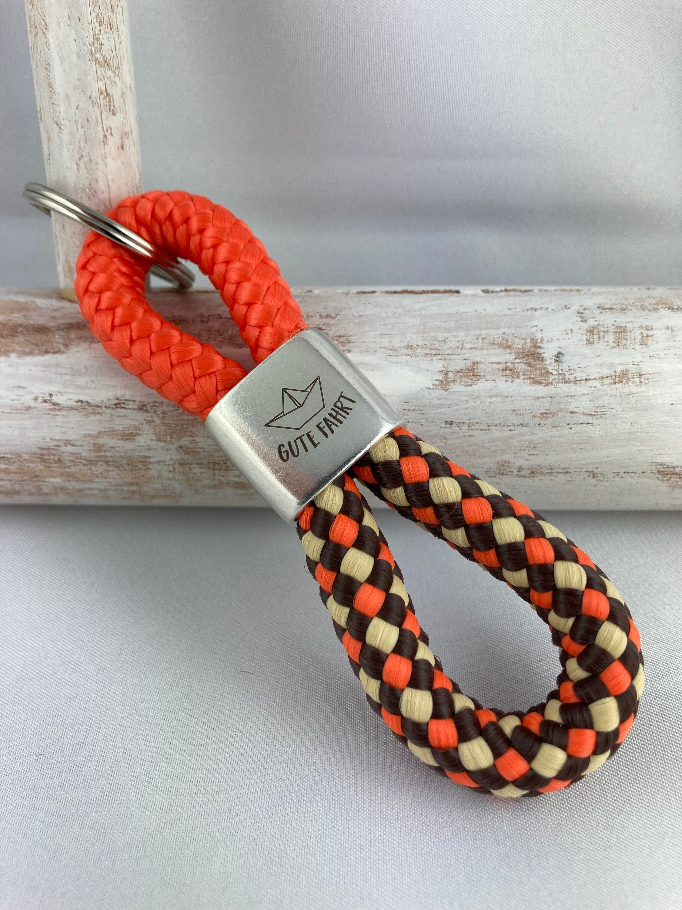 Schlüsselanhänger aus Segelseil mit versilbertem Zwischenstück mit Gravur "Gute Fahrt und Papierschiffchen", orange/ braun-beige-orange