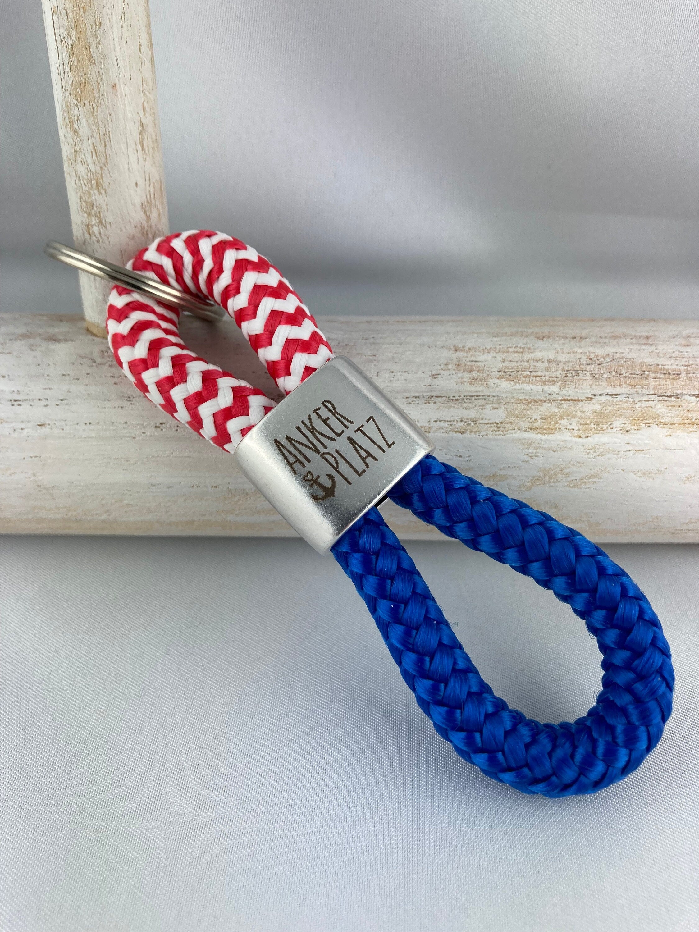 Schlüsselanhänger aus Segelseil mit versilbertem Zwischenstück mit Gravur "Ankerplatz", rot-weiß/ blau