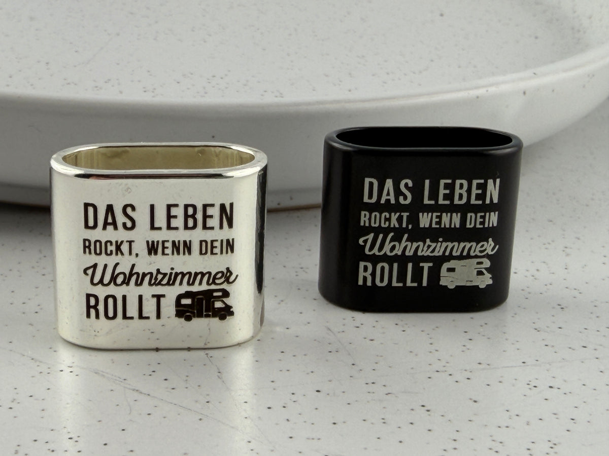 Detailaufnahme der Gravur mit dem Spruch "Das Leben rockt, wenn dein Wohnzimmer rollt" auf dem Zwischenstück