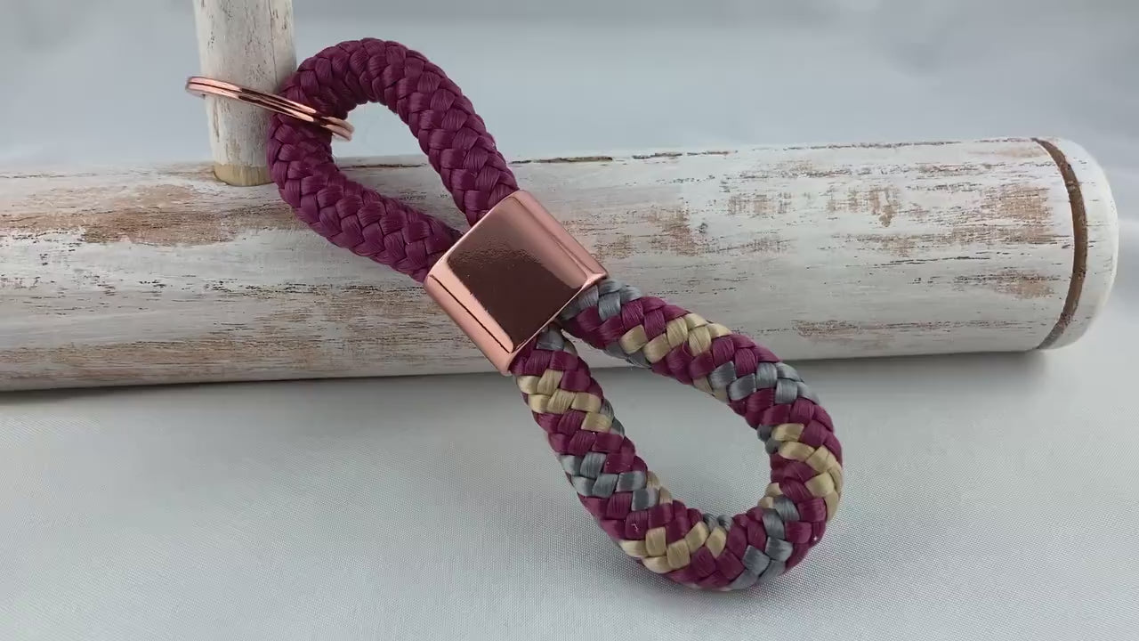 Schlüsselanhänger aus Segelseil mit Zwischenstück roségoldfarben, aubergine/ aubergine-grau-beige