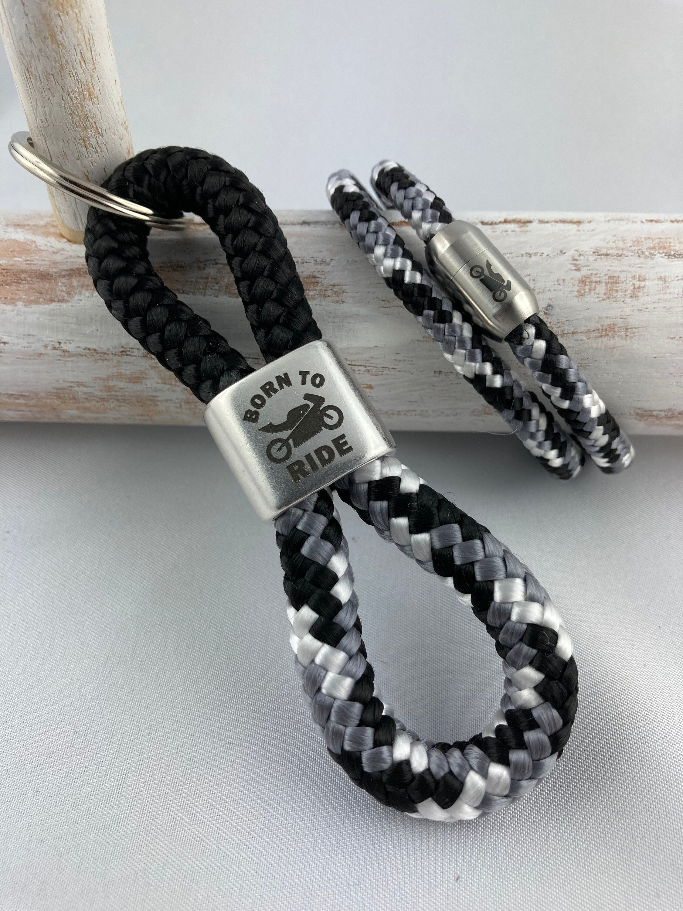 Set Schlüsselanhänger mit versilbertem Zwischenstück mit Gravur "Born to ride" und Armband mit Magnetverschluß aus Edelstahl mit Motorrad