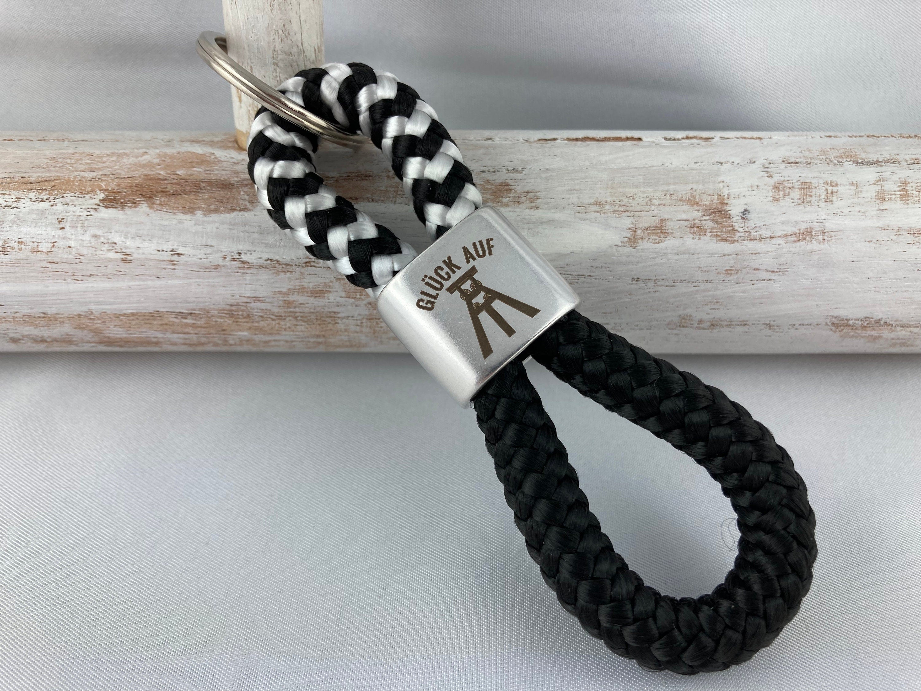 Schlüsselanhänger aus Segelseil mit versilbertem Zwischenstück mit Gravur "Glück auf", schwarz-weiß/ schwarz